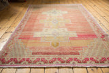 Faint foundation visible through worn pile, with secured fringe and geometric border pattern.