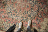 Distressed vintage Oushak carpet, with worn rose, charcoal, and ivory quatrefoil medallion.