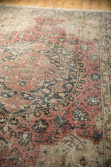 Sprawling arabesque design and worn texture in blush rose and charcoal on a vintage Oushak rug.