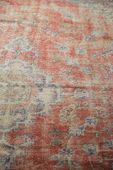 Visible foundation and faded cherry red, ivory, royal blue tones on a distressed Oushak.