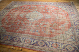 Distressed Oushak rug border featuring faded cherry red, royal blue, and ivory floral vinery.