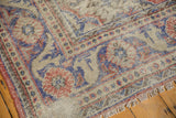 Distressed Oushak carpet fringe and edge, showing faded red, royal blue motifs, exposed foundation.