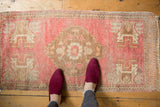 Distressed Oushak runner showcasing a faded blush and antique ivory stepped medallion.