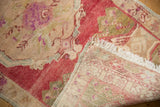 Distressed vintage Oushak rug showing low pile texture, fringe, and hand-knotted backing.