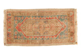 Distressed vintage Oushak rug with geometric lozenge medallion, dusty red and teal tones.