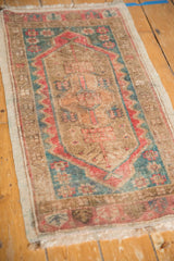 Distressed Oushak rug corner with low pile, original side cord, and faded teal red border.