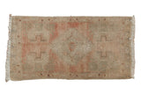 Distressed vintage Oushak runner with faded dusty rose stepped medallion, antique ivory field.