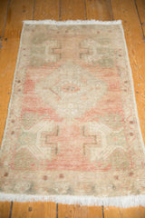 Vintage Oushak runner's distressed low pile in dusty rose and antique ivory.