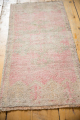 Distressed vintage Oushak rug mat with soft pink, beige, and silver low pile.