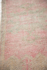 Distressed vintage Oushak runner's textured low pile, featuring blush and oxidized silver tones.