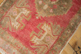 Distressed vintage Oushak rug with raspberry red and bronze geometric motifs.