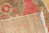 Close-up showing the vintage distressed Oushak rug's foundation, original side cord selvage, and fringe.