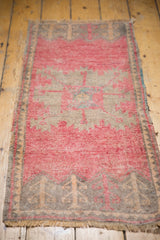Distressed Oushak rug corner with time-softened bubblegum pink, gray tones, and fringe.