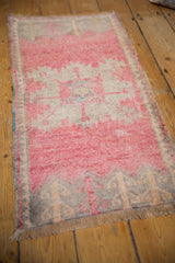 Distressed Oushak rug close-up: fringe, low pile, and pale tangerine plant motifs on silver.