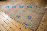 Textured Jijim carpet showing geometric pink and sky blue flowers, abrashes, and patterned border.