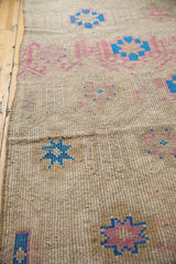 Geometric stylized flowers in sky blue and blush on a distressed Jijim carpet.