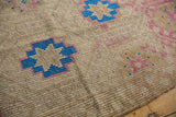 Distressed vintage Jijim carpet texture with sky blue and blush geometric flower motifs.