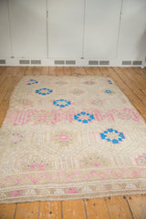 Vintage distressed Jijim rug corner showing geometric flowers, woven texture, and abrashes.