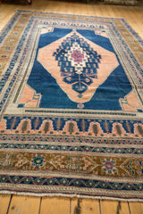 Close-up of Oushak carpet border, showing geometric patterns, apricot, bronze, dark navy, fringe.