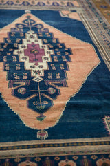 Stepped apricot and dark navy medallion with intricate outlining on vintage Oushak.