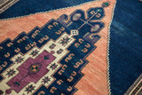Intricate outlining of the Vintage Oushak's dark navy and apricot stepped motifs and original selvage.