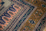 Intricate stepped borders in apricot, navy, and bronze on a vintage Oushak rug.