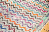 Hand-woven Jijim carpet with geometric zigzag pattern and multi-color banded end.