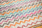 Rainbow zigzag pattern and woven border detail on a vintage Jijim carpet.