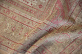Soft fold revealing the low, hand-knotted pile and distressed texture of a vintage Oushak carpet.