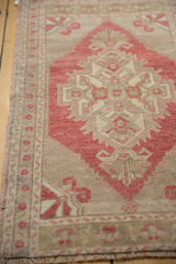 Distressed low pile and geometric pattern in pale cherry red and ivory tones.