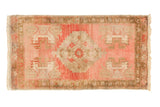 Distressed vintage Oushak rug, faded cherry red and pale bronze with a central stepped medallion.