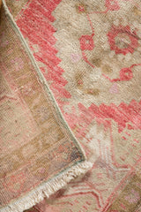 Original side cord selvage and hand-knotted fringe of a vintage distressed Oushak rug.