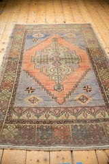 Distressed hand-knotted Oushak rug runner showcasing muted terracotta, slate blue, and geometric borders.