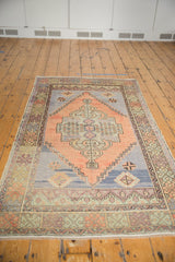 Distressed vintage Oushak runner featuring a central stylized medallion in soft apricot, blue, and ivory.