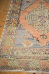 Distressed Oushak runner texture, showing stepped motifs in terra cotta and muted blues.