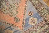 Textured pile detail of distressed Oushak runner with apricot field and blue geometric patterns.