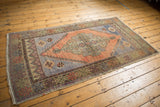 Distressed Oushak rug corner, showing stepped spandrel, intact selvage, and muted tones.