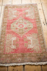 Distressed vintage Oushak rug showing serrated contour and geometric plant motifs in blush and ivory tones.