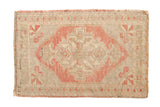 Distressed vintage Oushak rug mat with a faded blush and ivory geometric medallion, 2' x 3'1