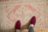 Distressed Oushak rug with blush geometric medallion and soft ivory, pale green accents.