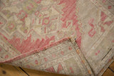 Distressed blush and ivory pile with intact selvage and hand-knotted back of vintage Oushak rug.