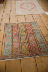 Short fringe and a patterned border on a distressed vintage Oushak rug, highlighting vertical vine motifs.