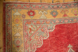 Distressed Oushak rug corner, saffron yellow border, cherry red field, Rococo motifs.