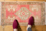 Distressed texture and faded tones on the upper corner of a vintage Oushak rug.
