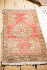 Distressed texture revealing faded cherry red and pale bronze brown motifs in an Oushak rug.