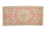Distressed vintage Oushak rug with blush pink field, ivory medallion, and stylized plant motifs, 1'7