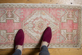 Distressed Oushak rug's soft pink, ivory, and brown hues with even wear.