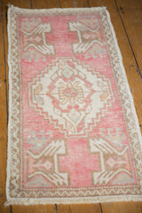 Evenly worn pale pink field with serrated ivory medallion on this distressed Oushak rug.