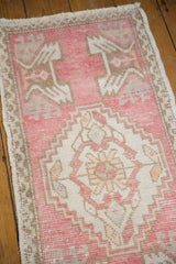 Blush pink Oushak rug's serrated medallion and distressed texture with visible wear.