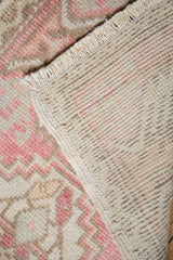 Distressed pink Oushak rug pile with visible hand-knotted foundation.